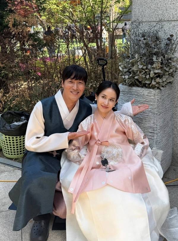 Actress Cho Yeo-jeong shared behind-the-scenes photos on her social media of herself dressed in a wedding dress and Hanbok with Kim Jae-chul during the filming of the Coupang Play series *Adultery Is Not the Issue Right Now*. Although they appear in the series as a former couple in the midst of a divorce lawsuit, the actual filming set displayed a warm and friendly atmosphere, revealing a contrasting charm.Cho Yeo-jeong perfectly recreated the look of a bride, posing affectionately with Kim Jae-chul while wearing a wedding dress and a traditional Korean hanbok for the Pyebaek ceremony. Scenes reminiscent of a real wedding, such as a kiss on the cheek directed at Kim Jae-chul, particularly caught the eye.In the series, Cho Yeo-jeong plays the role of Su-jeong, a dermatologist, while Kim Jae-chul plays the role of her ex-husband, Bo-seong, portraying a conflicting relationship engaged in a messy divorce lawsuit. Cho Yeo-jeong mentioned that they live as a loving couple off-camera, conveying the atmosphere on set that contrasted sharply with their on-screen relationship.Adultery Is Not the Issue is a black comedy drama about a popular influencer couple and a doctor couple who become entangled in a huge secret. Starring Kim Hye-soo, Cho Yeo-jeong, Kim Ji-hoon, and Kim Jae-chul, it was released on Coupang Play on July 31.
