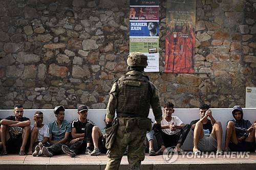 스페인 군인이 모로코로 돌려보낼 이민자들을 감시하고 있다.  [AFP=연합뉴스. 재판매 및 DB 금지]