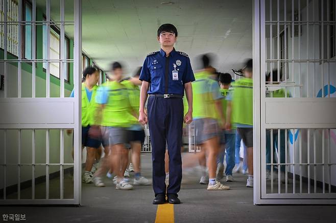 지난달 14일 경남 진주교도소에서 한 교도관이 수용자들 사이에 서 있다. 진주=장련성 기자
