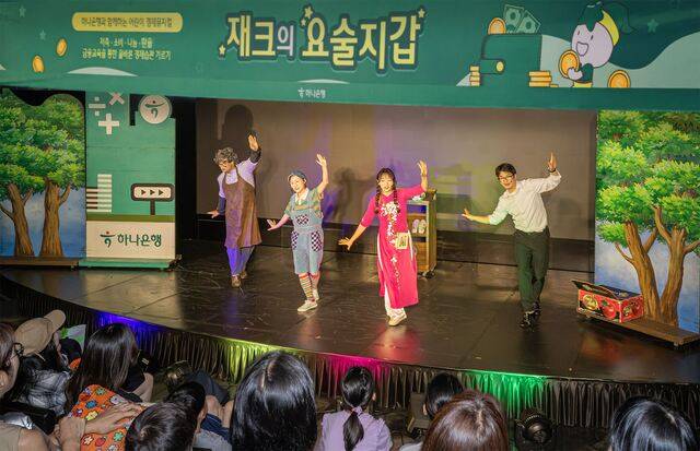 하나은행은 지난 5일 서울시 마포구에 위치한 문화 공간 H-Pulse에서 여름방학 맞이 어린이 경제 뮤지컬 ‘재크의 요술지갑’ 공연을 개최했다. 이날 공연에 초청 받은 다문화 가족 어린이들이 뮤지컬을 관람하고 있다. /하나은행 제공