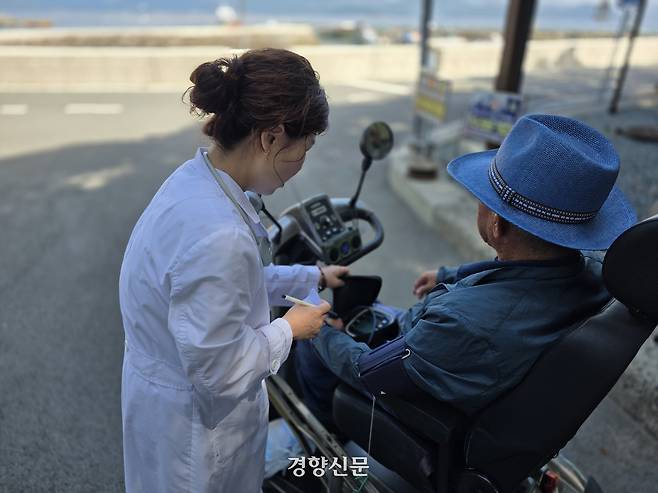지난 7월 24일 경남 통영시 사량면 내지마을을 찾은 병원선(경남511호) 소속 김은년 주무관이 진료실 방문이 어려운 마을 어르신을 위해 야외에서 혈압을 측정하고 있다. 통영 | 김찬호 기자