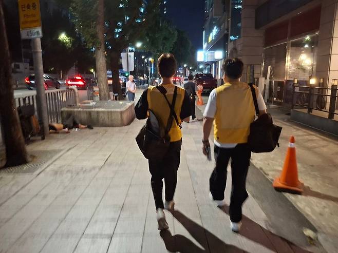 밤거리 순찰하는 사회복지사들 5일 오후 서울시립 '다시서기 서울역희망지원센터' 임종구(왼쪽), 정문영 사회복지사가 서울역 근처를 순찰하고 있다. 어깨에 멘 보냉백에는 노숙인들에게 나눠줄 얼음물과 빵이 담겨 있다. [촬영 황재하]
