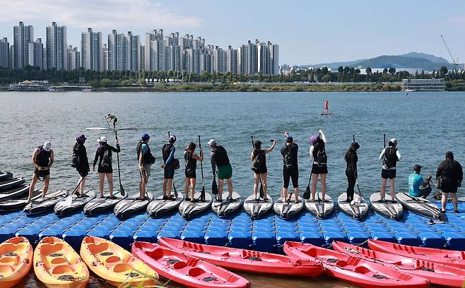 8일 서울 뚝섬한강공원 인근에서 열린 '블루웨이브챌린지 한강: 수상 마라톤' 행사에서 시민들이 패들보드를 타며 더위를 식히고 있다. 연합뉴스