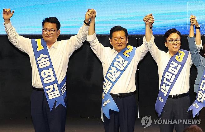 민주당 대구·경북 합동연설회 기념 촬영하는 당권 주자들 (대구=연합뉴스) 김현태 기자 = 9일 오후 대구 인터불고 엑스코 호텔에서 열린 더불어민주당 당 대표 및 최고위원 선출을 위한 대구·경북 합동연설회에서 당 대표 후보자들이 손을 잡고 기념 촬영하고 있다. 왼쪽부터 송영길 후보, 정청래 후보, 김민석 후보. 2026.8.9 mtkht@yna.co.kr