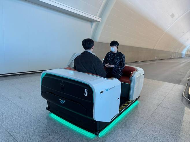 인천국제공항 제2여객터미널에서 여객들이 자율주행 셔틀 전동차(AM)를 타고 탑승구로 이동하고 있다. 인천공항공사는 제2터미널 확장 오픈으로 이동 거리가 늘어난 여객들의 불편을 해소하기 위해 고령자 등 교통약자와 탑승 임박 승객을 위한 자율주행 무인 모빌리티 서비스를 도입해 운영하고 있다. 공항공사 제공