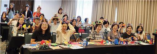 종이 왕관을 쓴 제27차 학술대회 참가 교사들 제27차 미주한국학교총연합회 학술대회에 참가한 한국어 교사들이 조영옥 대한민국 종이접기 지도사범 마스터 지도로 여왕 왕관 고깔과 우주비행선, 가면 등을 만들어 쓰고 포즈를 취하고 있다. [종이문화재단 제공]