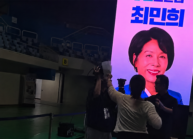 지난 8일 인천 남동체육관에서 열린 민주당 8·17 전당대회 합동연설회 현장에서 ‘최민희 후보’의 명찰을 단 사람이 취재 중인 오마이TV 기자들의 카메라를 막아서는 등 취재를 방해하는 사건이 벌어져 논란이 지속되고 있다. /황기자TV 캡처