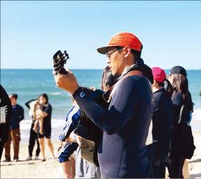 지난해 6월 충남 태안 만리포해변에서 열린 서핑 예배 현장에서 통기타를 연주하며 찬양하는 윤 선교사. 크리스천서퍼스코리아 제공