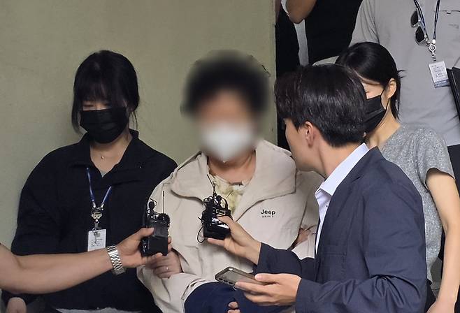 11세 아동을 학대해 숨지게 한 혐의(아동학대치사)를 받고 있는 천안의 한 교회 목사 A 씨(62·여)가 14일 충남 천안시 동남구 천안동남경찰서 유치장에서 검찰로 송치되고 있다. [뉴스1]