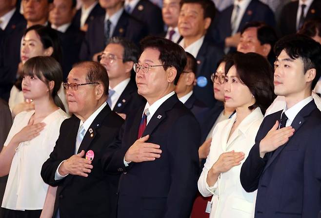이재명 대통령과 김혜경 여사가 15일 서울 종로구 세종문화회관에서 열린 제81주년 광복절 경축식에서 국기에 경례하고 있다. 연합뉴스
