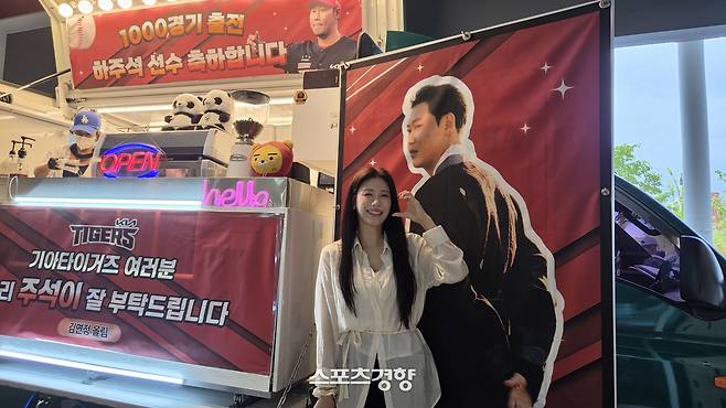 KIA 하주석의 아내이자 한화응원단 치어리더인 김연정 씨가 16일 광주-기아챔피언스필드에 남편의 통산 1000경기 출장 기념 커피 차를 쏘고 하주석 사진 앞에서 볼 하트를 그리고 있다. 광주 | 김은진 기자