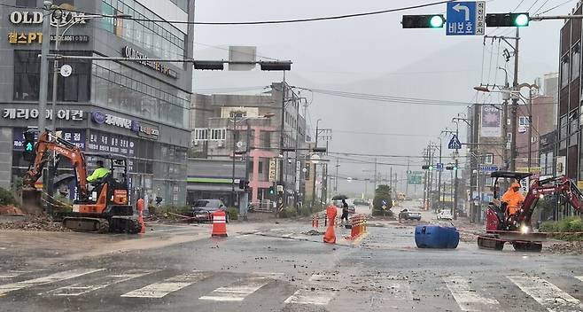 17일 새벽 물폭탄을 맞은 경남 거제시 도로 모습. 중장비들이 긴급 투입돼 복구작업을 벌이고 있다. 최상원 기자