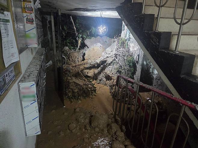 17일 오전 경남 거제시 옥포동 한 주택가에서 산사태로 흘러내린 토사와 나무 등이 건물 출입로를 막고 있다. 연합뉴스