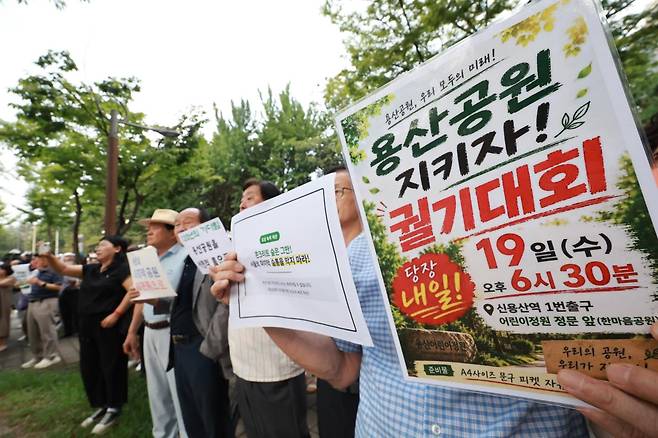 용산 주민들이 19일 서울 용산구 한마음공원에서 열린 '용산어린이정원 사수 궐기대회‘에서 피켓을 들며 용산어린이정원 일대 주택 공급 개발을 반대하고 있다. 뉴스1