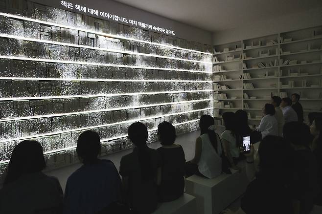 Audience members watch a video projected upon an installation piece at “The Third Poem: Come Home Again” exhibition, a solo show by Es Devlin, at Futura Seoul in Jongno District, central Seoul on Aug. 14. FUTURA SEOUL