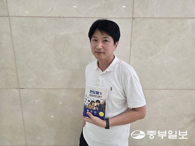 홍정표 작가가 자신의 저서 '반도체가 사라진다면?'을 들고 포즈를 취하고 있다. 이준도기자
