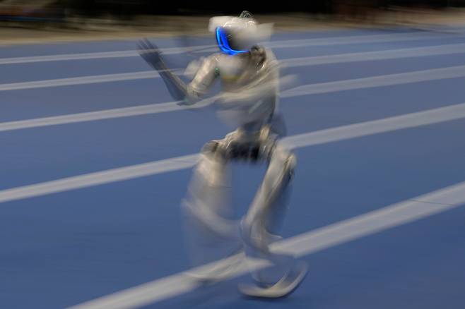 18일 중국 베이징에서 2026 세계휴머노이드로봇대회를 앞두고 한 로봇이 400m 경기를 위한 시험 주행을 하고 있는 모습을 장노출로 촬영한 장면. /AP 연합뉴스