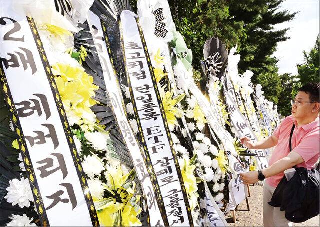 개인투자자 단체인 ‘주식시장 정상화를 위한 모임’ 관계자가 지난달 29일 서울 여의도 국회의사당 앞에서 단일종목 레버리지 상장지수펀드(ETF) 폐지를 촉구하는 근조화환을 설치하고 있다. 개인투자자들의 손실이 커지는 등 우려가 제기되자 금융 당국은 기본예탁금을 상향 조정하는 등 진입 장벽을 높였다. 권현구 기자