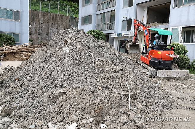 산더미처럼 쌓인 토사…복구 한창 지난 21일 오전 경남 거제시 옥포동의 한 아파트에서 굴착기를 동원해 집중호우로 밀려든 토사를 치우는 복구작업이 이뤄지고 있다. 이 아파트에서는 지난 17일 집중호우로 토사가 유출돼 사상자가 발생했다.