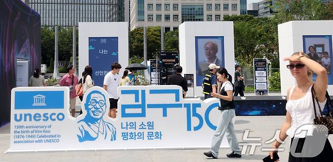 26일 서울 종로구 광화문 광장에서 관광객들이 ‘김구 탄생 150주년 조형물’을 살펴보고 있다. 2026.8.26 ⓒ 뉴스1 이종덕 기자