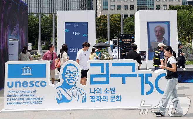 26일 서울 종로구 광화문 광장에서 관광객들이 ‘김구 탄생 150주년 조형물’을 살펴보고 있다. 2026.8.26 ⓒ 뉴스1 이종덕 기자
