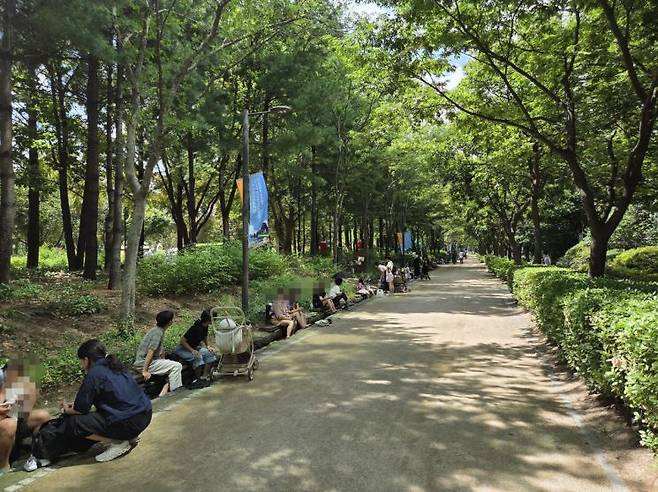 낮 기온이 34도까지 오른 지난 23일, 시민들이 서울숲공원 나무 그늘 아래 작은 물길에 발을 담그며 더위를 식히고 있다.