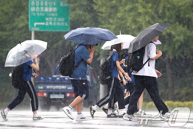 27일 오후 대구 수성구 달구벌대로 담티고개 인근에 천둥번개를 동반한 비가 내리자 하굣길 학생들이 발걸음을 재촉하고 있다. 2026.8.27 ⓒ 뉴스1 공정식 기자