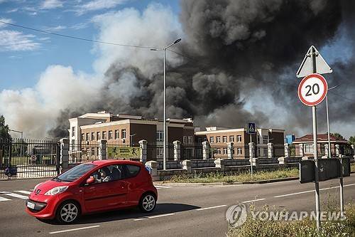 2026년 8월 29일(현지시간) 우크라이나 키이우주(州)에서 러시아의 드론 공습으로 연기가 피어오르는 현장 옆을 차 한 대가 지나가고 있다. [로이터 연합뉴스. 재판매 및 DB 금지]