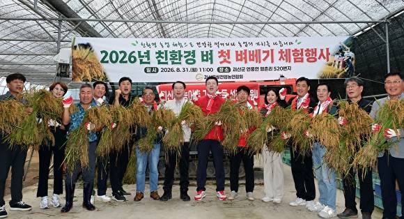 연풍면 행촌리 김영국씨 농가에서 열린 친환경 벼 베기 행사 참석자들이 기념 촬영을 하고 있다. [사진=괴산군]
