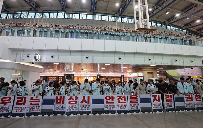 한국철도공사(코레일)와 에스알(SR)의 기관통합을 완료하고  KTX·SRT 통합 운행을 시작한 1일 서울역에서 열린 '철도 안전체계 이원화 국토부·한국철도공사 규탄 KTX·SRT 승무원 기자회견'에서 참가자들이 안전업무도 통합하라 등이 적힌 손피켓을 들고 있다. /연합뉴스