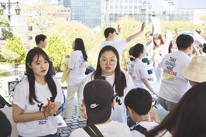 지난 4월 26일 서울 명동성당 앞에 마련된 2027 서울 세계청년대회(WYD) 홍보 부스에서 신자들이 설명하고 있다.    천주교서울대교구 제공