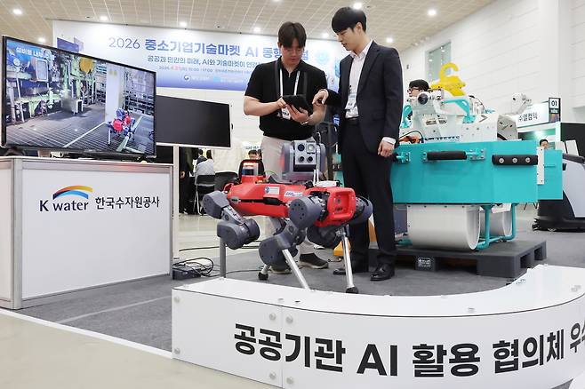 21일 세종시 정부세종컨벤션센터에서 열린 ‘2026 중소기업기술마켓 AI 동행포럼’에서 한국수자원공사와 AI로봇 개발업체 관계자가 정수장 점검에 활용될 AI 로봇을 시연하고 있다. [연합]