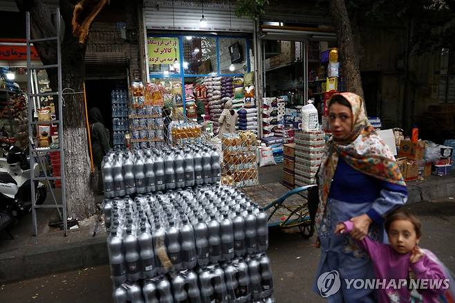 이란 수도 테헤란의 한 상점 앞을 지나는 사람들 [로이터=연합뉴스 자료사진. 재판매 및 DB 금지]