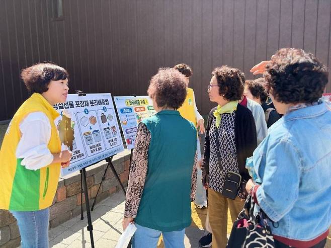 신천지 자원봉사단 봉사자가 반기문 교차로와 자유시장 일대에서 시민들에게 올바른 분리배출에 대해 설명하고 있다.(사진=신천지 자원봉사단 충주지부 제공)