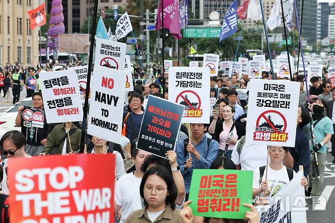 [서울=뉴시스] 황준선 기자 = 12일 서울 종로구 세종대로 사거리 인근에서 열린 '미국은 침략전쟁 중단하라! 정부는 호르무즈 파병 단호히 거부하라! 시민 대행진'에서 참석자들이 청와대를 향해 행진하고 있다. 2026.09.12. hwang@newsis.com