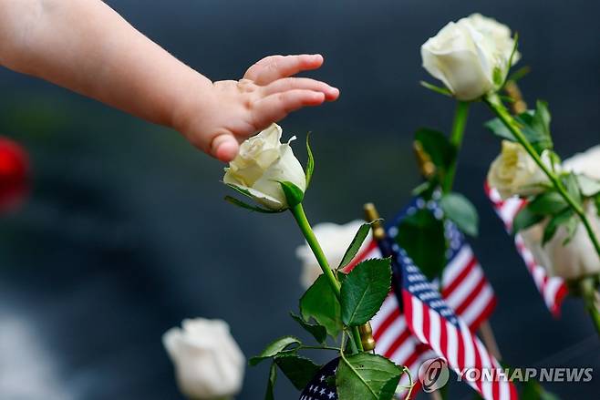 25th ANNIVERSARY 9/11 A child touches a flower next to the reflecting pools during a remembrance ceremony marking the 25th anniversary of the 9/11 attacks at the National September 11 Memorial & Museum at Ground Zero in New York on Friday, September 11, 2026. A total of 2,753 people died in the attack on the World Trade Center on September 11, 2001. Pool Photo by Jeenah Moon/UPI
