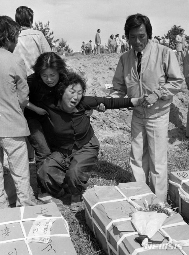【광주=뉴시스】변재훈 기자 = 18일 오전 5·18민주화운동 39주년 기념식이 열린 가운데 문재인 대통령이 1980년 5월21일 광주 금남로에서 계엄군의 총에 맞아 숨진 김완봉 군(당시 15세)의 묘를 찾아 참배했다. 사진은 당시 김 군의 어머니가 아들의 관 앞에서 오열하고 있는 모습. 2019.05.18. (사진=5·18기념재단 제공)photo@newsis.com