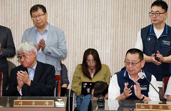 김정환 서울시버스사업조합 이사장과 박점곤 서울시버스노동조합 위원장이 16일 서울 영등포구 서울지방노동위원회에서 열린 특별조정위원회 2차 사후 조정 회의에서 서울 시내버스 노사 협상에 극적으로 합의한 뒤 박수를 치고 있다./뉴스1