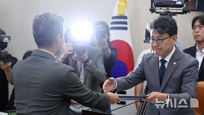 [서울=뉴시스] 고범준 기자 = 강신철 국방부 장관 후보자가 16일 서울 여의도 국회 국방위원회에서 열린 인사청문회에서 선서문을 진성준 위원장에게 전달하고 있다. 2026.09.16. bjko@newsis.com
