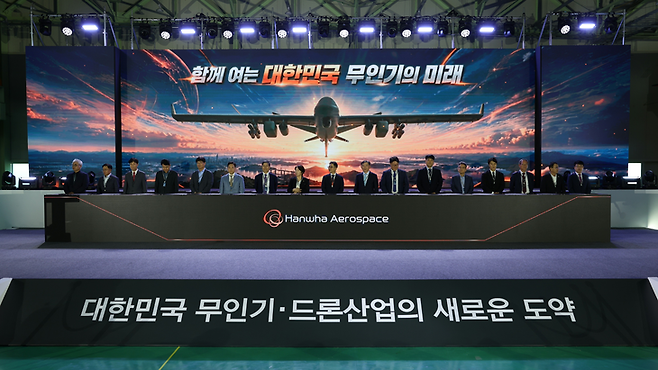 ▲21일 경남 창원특례시 한화에어로스페이스 창원1사업장에서 진행된 '산∙학∙연 상호 협력 협약식'에서 국내 무인기·드론 업계 관계자들이 기념 사진을 찍고 있다. 사진=한화에어로스페이스
