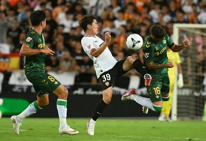 Valencia's Japanese defender #39 Ryunosuke Sato fights for the ball with Real Betis' Argentine defender #16 Valentin Gomez during the Spanish league football match between Valencia CF and Real Betis at Mestalla Stadium in Valencia on August 25, 2026. (Photo by JOSE JORDAN / AFP)<저작권자(c) 연합뉴스, 무단 전재-재배포, AI 학습 및 활용 금지>