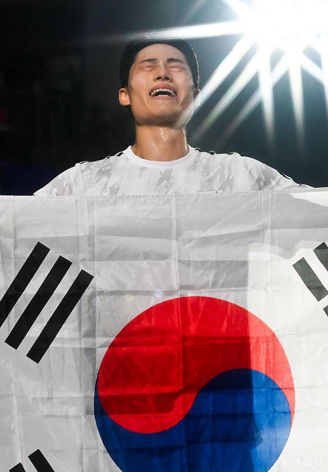 이준석이 20일 일본 나고야 히가시 스포츠센터에서 열린 2026 아이치-나고야 아시안게임 남자 단식 결승에서 금메달을 확정한 뒤 태극기를 들고 감격의 눈물을 흘리고 있다. 나고야=변영욱 기자 cut@donga.com