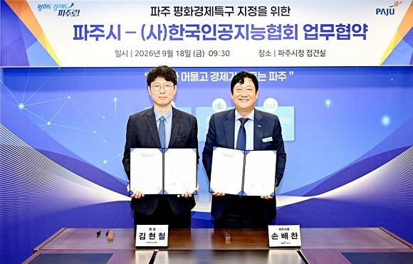 손배찬 파주시장(오른쪽)과 김현철 사단법인 한국인공지능협회장이 '파주 평화경제특구 인공지능 산업 발전을 위한 업무협약'을 체결한 뒤 협약서를 들어 보이며 기념촬영을 하고 있다. [사진=파주시]