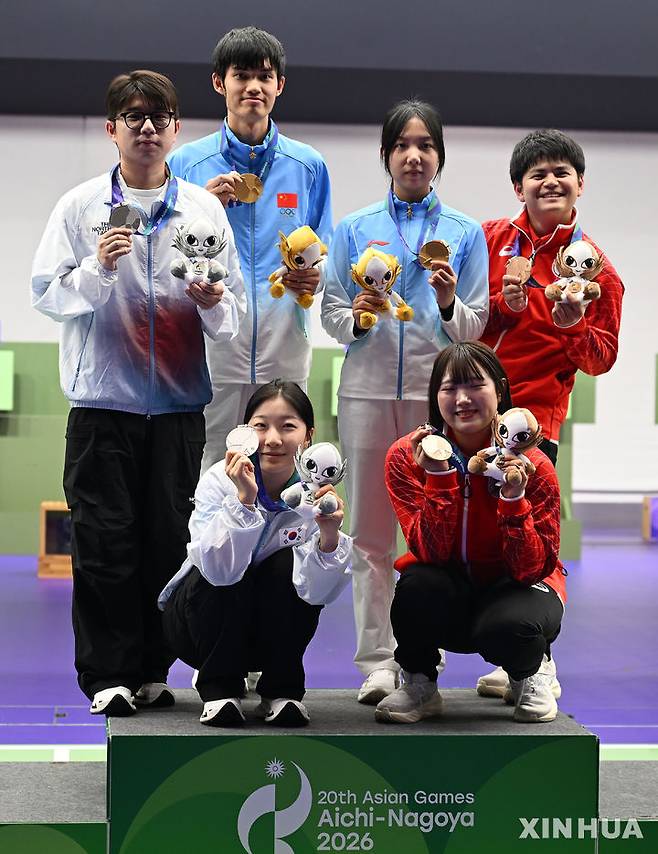 [도요타=신화/뉴시스] 한국 공기소총 박하준-반효진(왼쪽)이 22일 일본 아이치현 도요타에서 열린 2026 아이치·나고야 아시안게임 사격 10m 공기소총 혼성 단체전에서 은메달을 따낸 뒤 시상대에 올라 다른 수상자들과 함께 기념 촬영하고 있다. 박하준과 반효진은 결선에서 502.9점을 합작하며 2위에 올랐다. 2026.09.22.