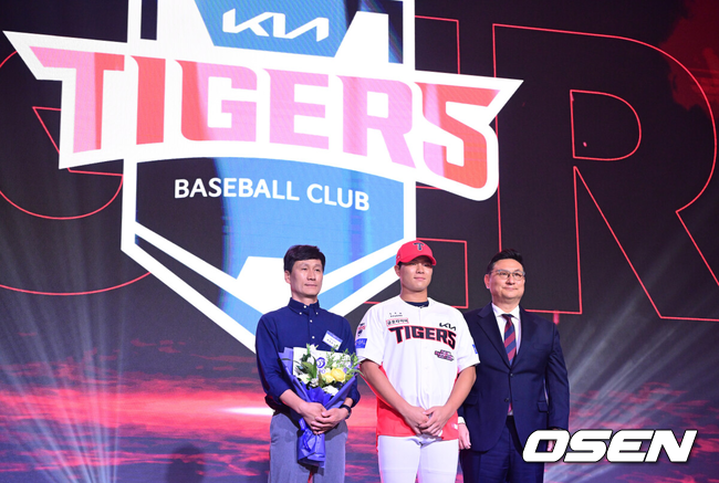 [OSEN=최규한 기자] 21일 오후 서울 잠실동 롯데호텔 월드 크리스탈볼룸에서 ‘2027 KBO 신인드래프트’가 열렸다. 이번 신인드래프트는 2025시즌 순위의 역순에 따라 키움 히어로즈, 두산 베어스, KIA 타이거즈, 롯데 자이언츠, KT 위즈, NC 다이노스, 삼성 라이온즈, SSG 랜더스, 한화 이글스, LG 트윈스 순서로 1라운드부터 11라운드까지 지명할 수 있다. 경남고 이호민이 전체 3번으로 KIA 타이거즈에 지명된 뒤 심재학 단장과 기념촬영을 하고 있다. 2026.09.21 / dreamer@osen.co.kr