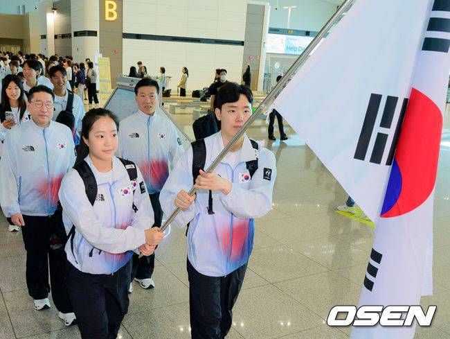 [OSEN=지형준 기자] 2026 아이치-나고야 아시안게임 대한민국 선수단 본단이 17일 오전 인천국제공항을 통해 일본으로 출국했다.아이치-나고야 아시안게임은 19일부터 10월 4일까지 일본 아이치현과 나고야시 일원에서 열린다. 대한민국은 41개 종목에 1,052명의 선수단을 파견한다. 선수 대표 탁구 신유빈, 배드민턴 서승재가 태극기를 들고 출국장으로 향하고 있다. 2026.09.17 / jpnews@osen.co.kr