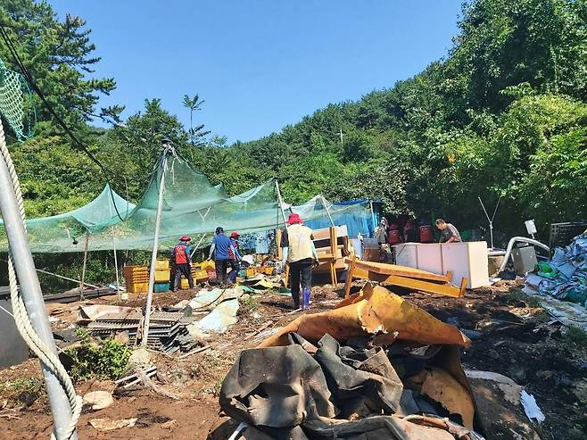 올 여름 수해를 입은 경남 통영시 산양읍의 한 농가. 자원봉사자들이 폐기물을 치우며 복구 작업을 하고 있다. 조성규 제공