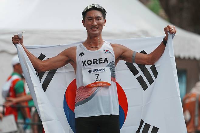 최병광이 23일 일본 나고야에서 열린 2026 아이치·나고야 아시안게임 남자 하프마라톤 경보에서 3위를 차지한 뒤 태극기를 몸에 두르고 포즈를 취하고 있다. 사진 제공=대한육상연맹
