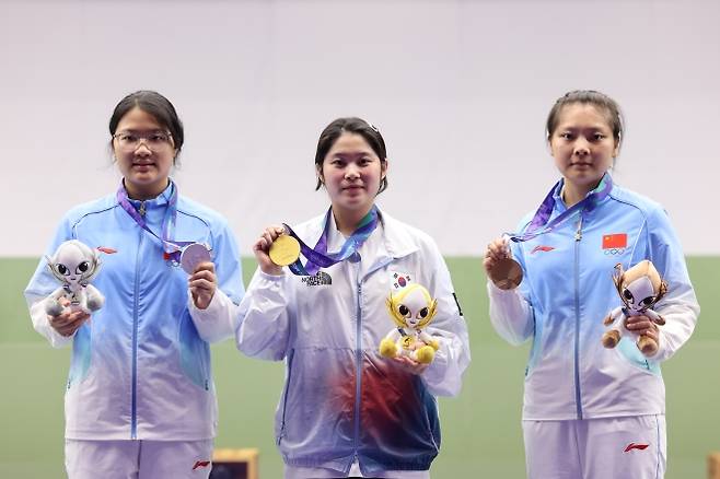 추가은이 23일 일본 아이치현 도요타시 종합사격장에서 열린 2026 아이치·나고야 아시안게임 사격 여자 10m 공기권총 개인전 결선에서 표적에 총구를 겨누고 있다. 작은 사진은 추가은이 시상식에서 금메달을 들어 보이는 모습. 도요타 뉴스1