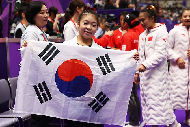 황서현이 25일 일본 나고야 종합체육관 레인보우홀에서 열린 2026 아이치·나고야 아시안게임 여자 평균대 결선에서 우승한 뒤 태극기를 펼쳐 보이고 있다. 나고야/로이터 연합뉴스